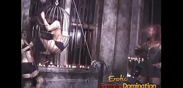  Two kinky mistresses take it out on a caged brunette slave